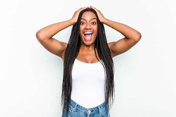 Молода афро-американська жінка ізольована на білому фоні крики, дуже збуджені, пристрасні, задоволені чимось. - Фото, зображення