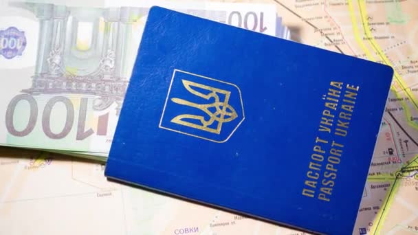 Pasaporte ucraniano con billetes se encuentra en el mapa. Salida de refugiados debido a la guerra en Ucrania - Imágenes, Vídeo