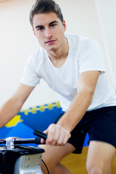 Young people with fitness bicycle in the gym. - Valokuva, kuva