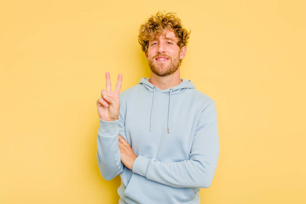 Young caucasian man isolated on yellow background showing number two with fingers. - Photo, Image
