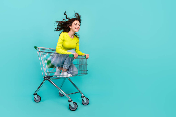Full length photo of sweet brunette hair millennial lady ride in trolley look pomo wear top jeans shoes isolated on teal color background. - Foto, immagini