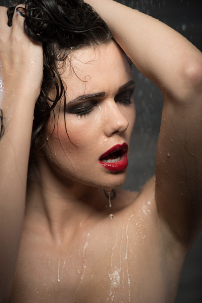 Hot sexy brunette woman in water studio, dark background - Фото, изображение