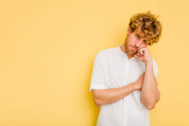 Young caucasian man isolated on yellow background who feels sad and pensive, looking at copy space. - Photo, Image