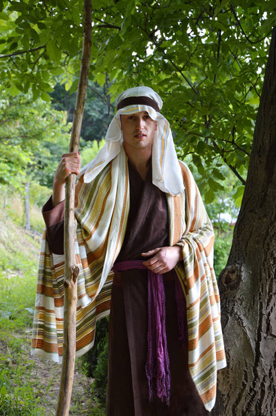 Retro rural rustic adult age islam forest travel nomad male human guy hold wood staff farm worker think pray love hope face. Middle east asian robe cloth holy Israeli Lord God Jesus faith believ story - Photo, Image