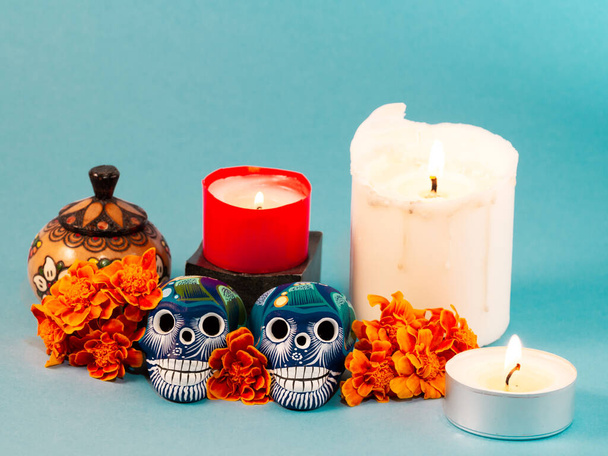 Spanisches traditionelles mexikanisches Herbstfest des toten typischen mexikanischen Schädels mit Blumen auf grünem Hintergrund, Dekorationen und Ringelblumen und Kerze mit Opfergaben Konzept Kopierraum - Foto, Bild