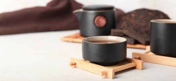 Soporte con taza de té puro en la mesa blanca - Foto, Imagen