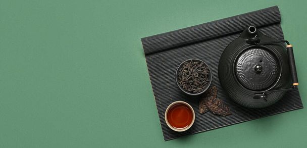Σύνθεση με υγιεινό puer τσάι σε πράσινο φόντο με χώρο για κείμενο, top view - Φωτογραφία, εικόνα