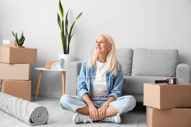 Mature woman sitting in living room on moving day - Foto, immagini
