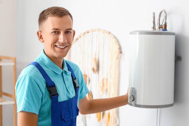 Männlicher Klempner installiert Boiler im Badezimmer - Foto, Bild