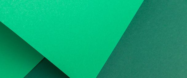 Green cardboard background design folded geometrically. Top view, flat lay. Banner.  - Zdjęcie, obraz