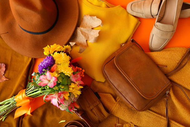 女性の服、アクセサリー、花やオレンジの背景に秋の葉の美しい花束、クローズアップ - 写真・画像