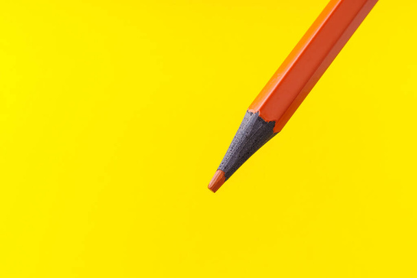 Colored pencil close-up with selective focus on the stylus and a blurred yellow background. Copy space for text. - Photo, Image