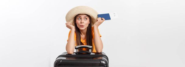 Concepto de viaje. Retrato del estudio de una mujer joven y bonita con pasaporte y equipaje. Aislado sobre blanco
. - Foto, Imagen