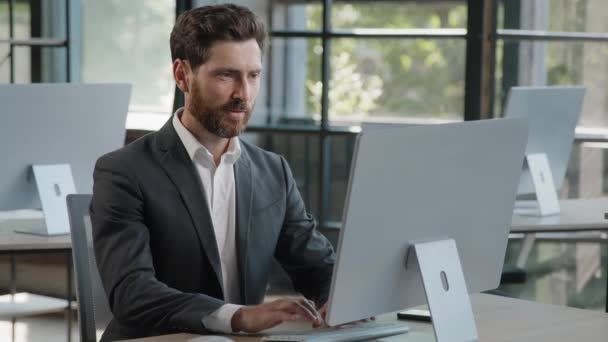 Successful adult bearded freelancer worker man at office working typing laptop smiling at camera. Portrait satisfied 40s businessman browsing laptop at workplace happy with new job in modern company - Footage, Video