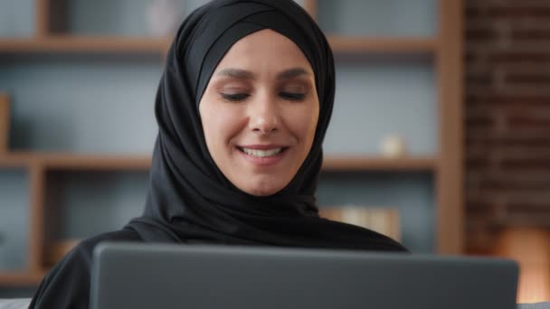 ラップトップ画面を見てヒジャーブのイスラム教徒のアラビア人のイスラム教徒の女性を閉じますコンピュータは、インターネットサービスストアでオンラインで電子商取引を監視し、ソーシャルネットワークでチャットを入力リモートブラウジング作業 - 映像、動画