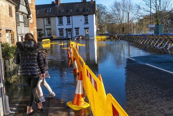 Bewdley, Worcestershire, Inglaterra, Reino Unido - 22 de fevereiro de 2022: As pessoas correm o risco de se molhar e o tráfego é proibido nas estradas ao redor do rio Severn, na cidade de Bewdley. - Foto, Imagem