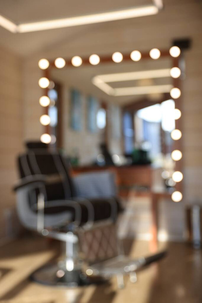 Blurred view of stylish barbershop interior with hairdresser workplace - Фото, изображение