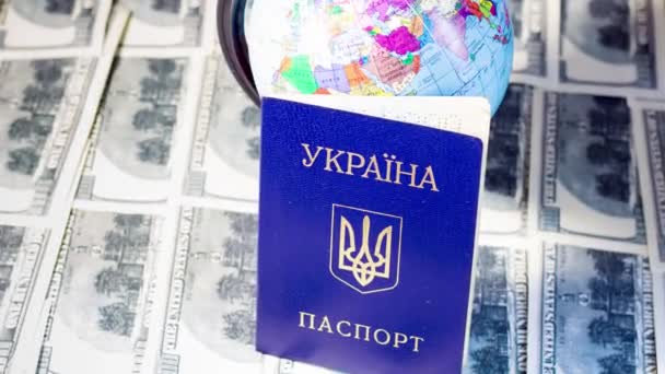 Pasaporte ucraniano en billetes cerca del globo. Salida de refugiados debido a la guerra en Ucrania - Imágenes, Vídeo