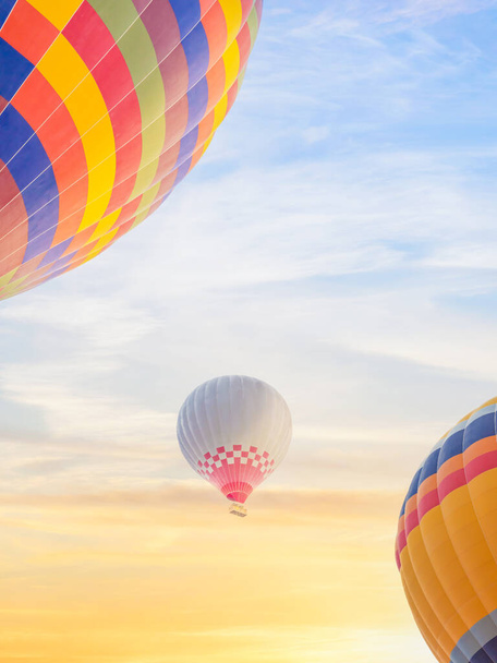 landscape scenery of multi color hot air balloon flying up over sunrise sky - Фото, изображение