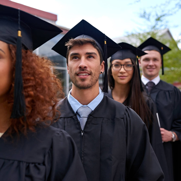 Продолжайте стремиться к более высоким достижениям. студенты университета в день окончания учебы стоят в очереди - Фото, изображение