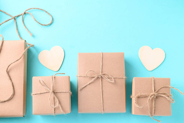 Boîte cadeau en papier avec forme de coeur sur fond de couleur bleu clair, cadeau artisanal pour donner en jour spécial et vacances - Photo, image