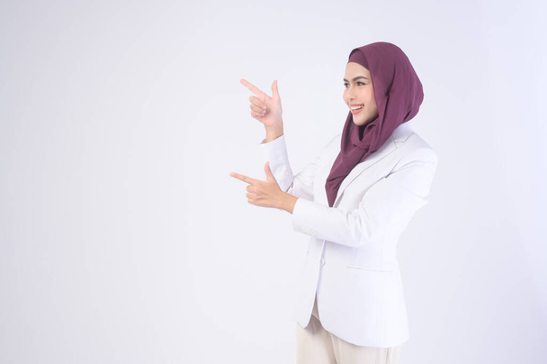 A Beautiful muslim business woman wearing white suit with hijab in studio	 - 写真・画像
