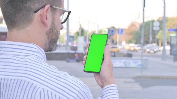 Adult Man Using Smartphone with Green Screen Outdoor - Fotografie, Obrázek