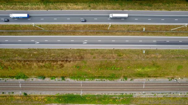 Вид с воздуха на перекрёсток шоссе. Дороги, железные дороги и зеленые поля на окраине города. в Бельгии Концепция транспорта. Качественная фотография, сделанная дроном - Фото, изображение