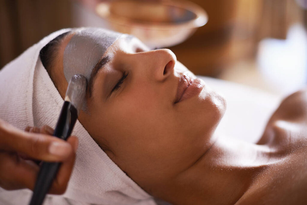 Where stress ends and relaxation begins...a young woman enjoying a facial treatment at a spa - Photo, Image