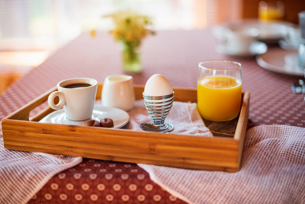 Śniadanie z jajkiem, sokiem pomarańczowym i kawą. Słoneczny poranek - Zdjęcie, obraz