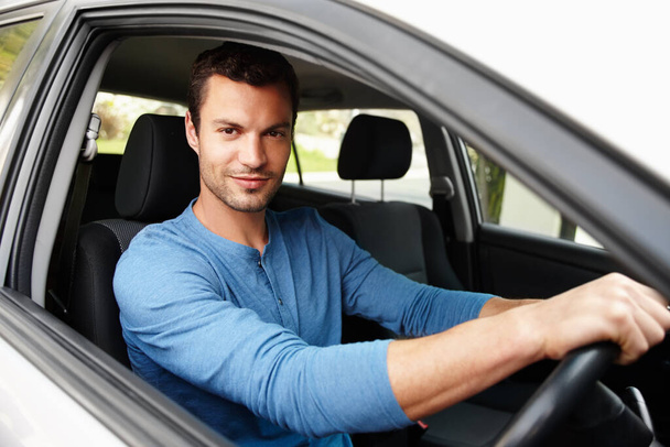 ¿Te gusta mi auto nuevo? Hombre atractivo sentado en su coche mirando a la cámara con las manos en el volante - Foto, Imagen