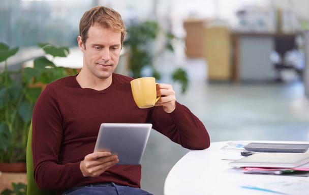 У него перерыв на кофе с Wi-Fi. Красивый бизнесмен, работающий за своим столом - Фото, изображение