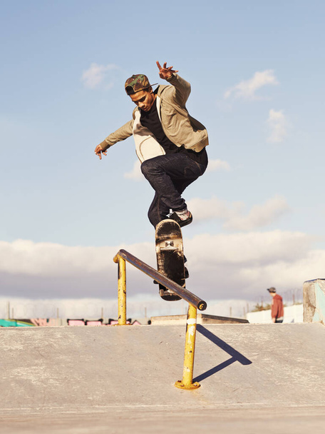 Grinding like a pro. a skateboarder performing a trick on a rail - Фото, зображення