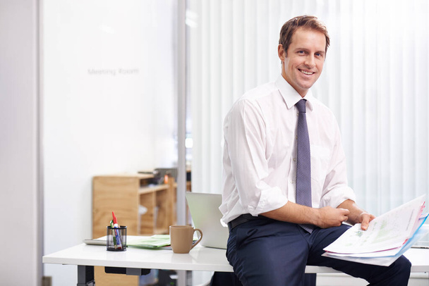 Корпоративна впевненість. Портрет красивого молодого бізнесмена, який читає через документи в своєму офісі
 - Фото, зображення