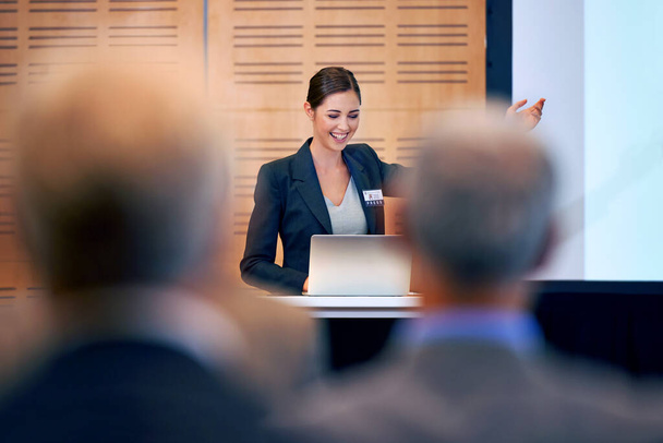 Un joven orador entusiasta. Una joven empresaria haciendo un gesto mientras da una presentación en una conferencia de prensa - Foto, Imagen