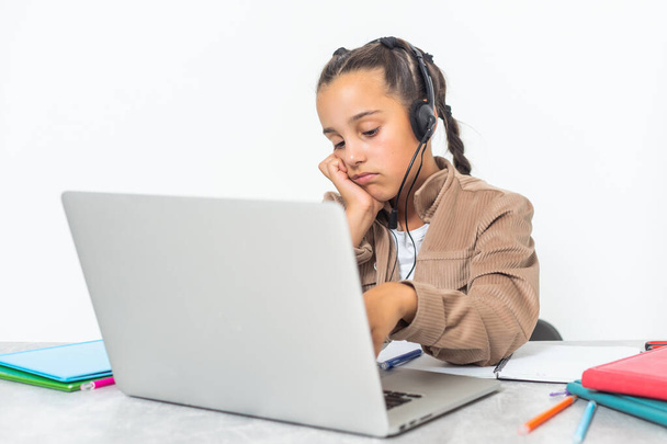 Distance learning online education. Photo of little upset and boring pupil. Little cute girl is bored and tired with doing her homework. New normal. Social distancing. - Foto, Imagem
