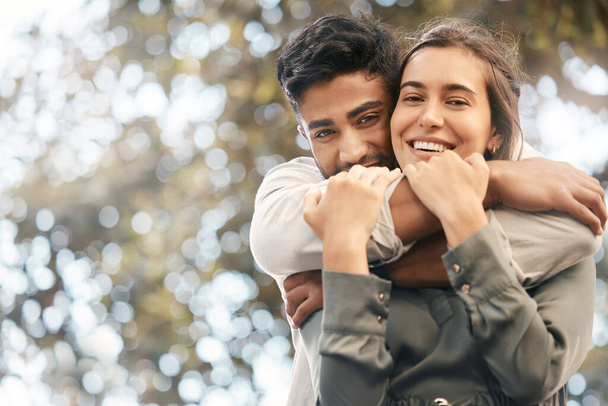 Couple hug, nature date and smile for love in summer, happy in park and affection with green trees in background with bokeh in garden. Face portrait of man and woman hugging in city spring. - 写真・画像