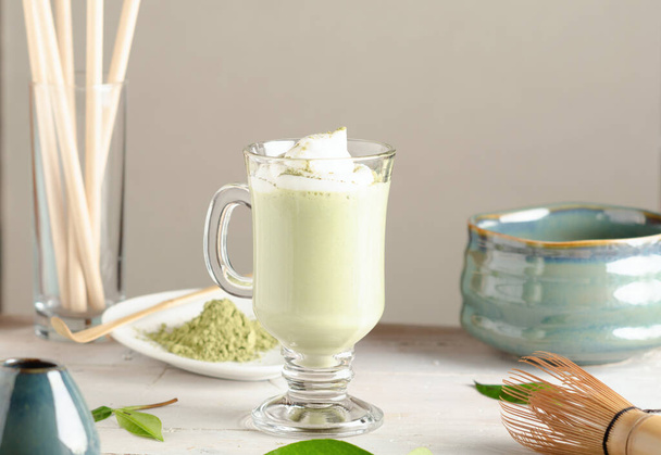 Matcha latte drink, tè verde con latte in vetro con accessori su fondo chiaro. - Foto, immagini