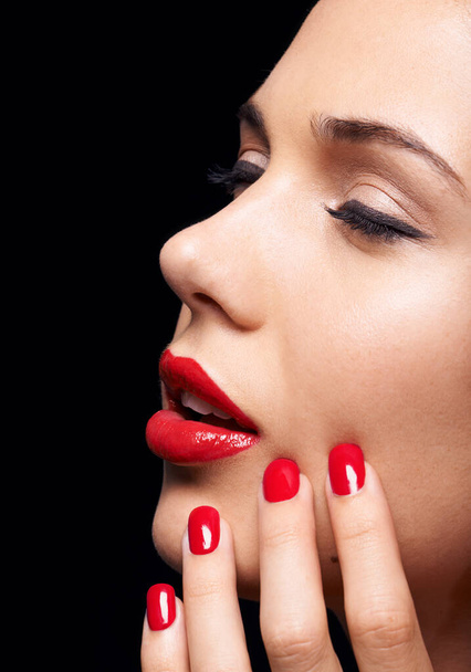 Una pasión por RED. Una foto de estudio recortada de una hermosa modelo con lápiz labial rojo y esmalte de uñas - Foto, Imagen