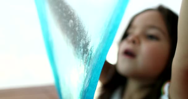 Malá holka hraje s slizký plasticine vytváří bublinu s - Záběry, video