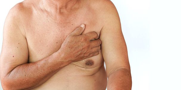 Een oudere man raakt zijn borst aan door pijn als gevolg van een geestesziekte of hartziekte. Concept van gezondheidsproblemen bij ouderen. - Foto, afbeelding