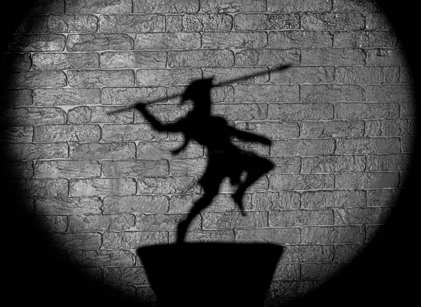 shadow of gladiator helmet on black background - Fotoğraf, Görsel