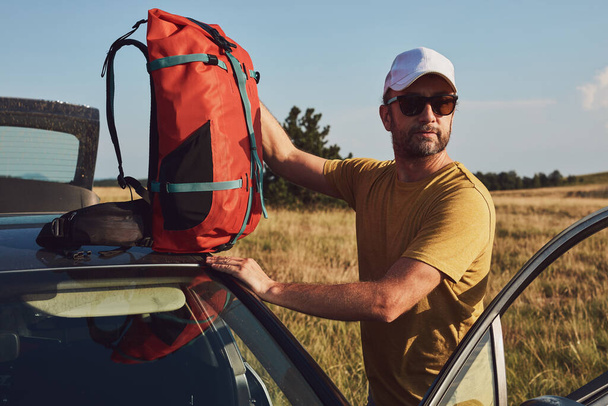 Hombre de camping y senderismo en la naturaleza, desembalaje del coche al aire libre, recreación y pasatiempos. - Foto, Imagen