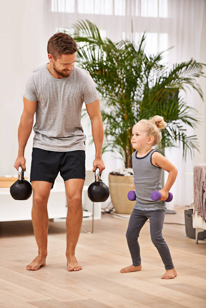 Strengthening their bond. Full length shot of a father and daughter working out together - 写真・画像
