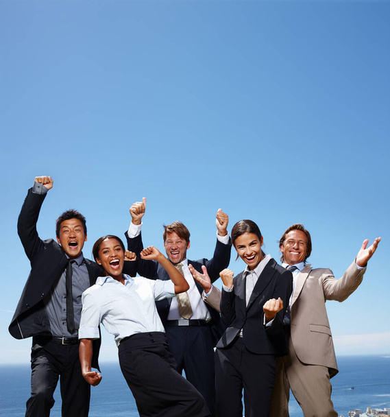 Le ciel dépasse les limites. un groupe de gens d'affaires agissant avec enthousiasme avec les mains en l'air - Photo, image