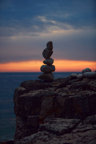 Silueta de piedras zen equilibradas en la playa del océano al atardecer al amanecer. - Foto, imagen