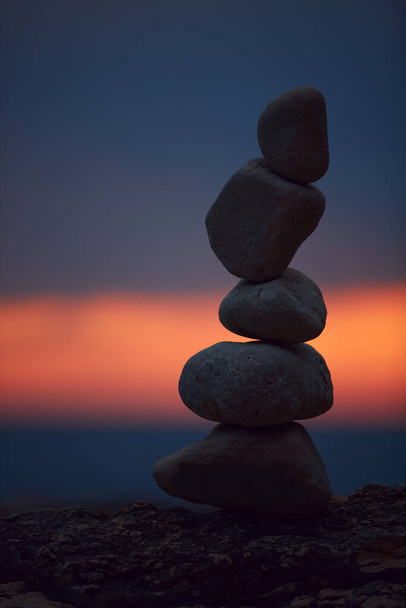 Sziluett kiegyensúlyozott zen kövek az óceán partján naplementekor. - Fotó, kép