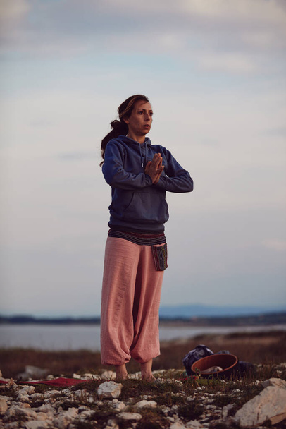 Жінка практикує йогу на відкритому повітрі під час заходу сонця
. - Фото, зображення