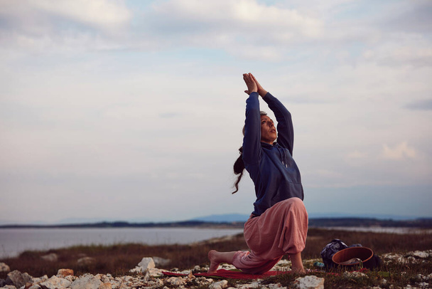 Mulher praticando ioga ao ar livre ao pôr do sol nascer do sol. - Foto, Imagem