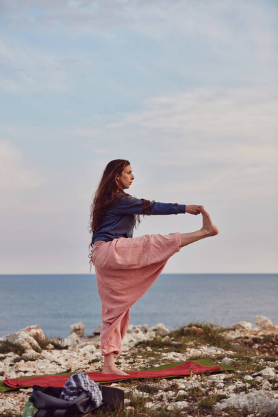 Donna che pratica yoga all'aperto al tramonto ora dell'alba. - Foto, immagini